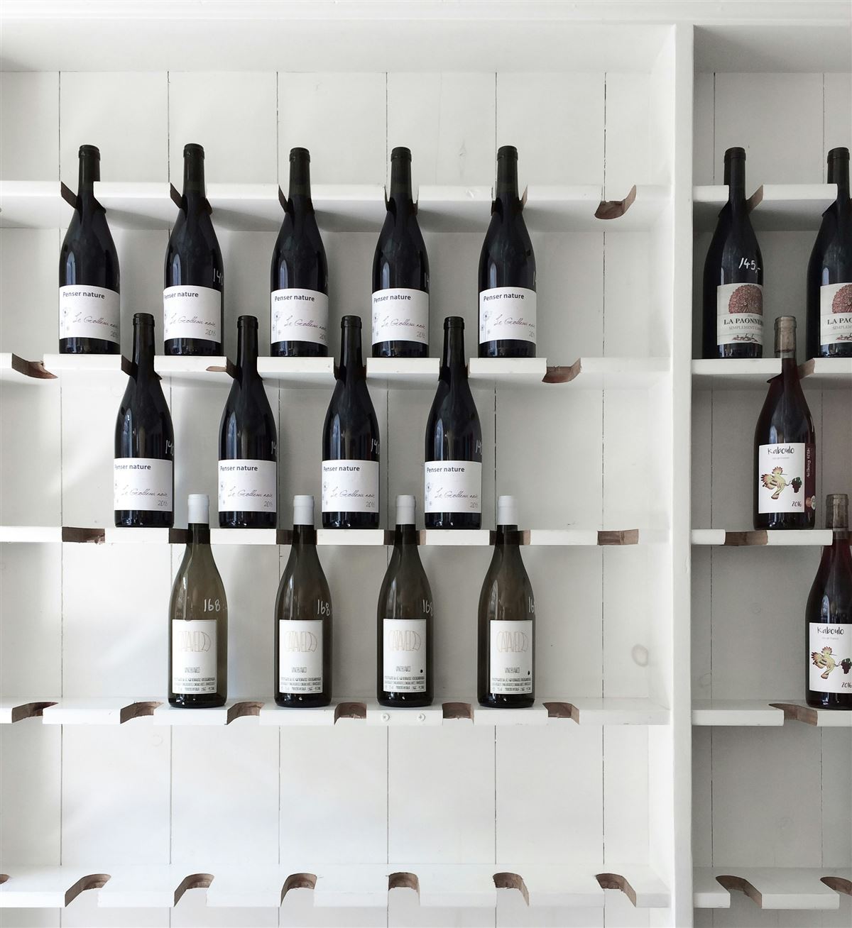 Estante blanco con botellas de vino tinto y blanco